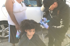 Wylie from the Country Club Barber shop cuts little homeless girl Lauren hair.