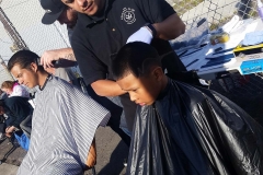 Santos is getting his hair cut on the streets in downtown San Diego.