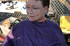A homeless woman smiles after looking at her new haircut