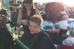 Sun lines paint the smile of a homeless women getting her hair cut on Easter