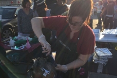 Kat cutting hair of a homeless women on Easter underneath the sprays of the sinking sun