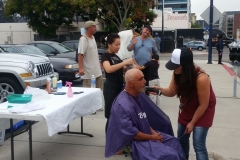 Eric waving while Tammy trims a San Diego homeless man's beard