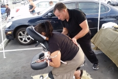 David massages a homeless women's back - notice her puppy.