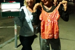 San Diego homeless ladies Terry and her friend hold up new shoes and tank top.