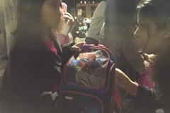 Arul gives little homeless girl Rickie a Spiderman backpack and blanket.