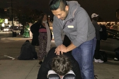 Jeremy, chiropractor for the homeless, adjust a homeless San Diego man's back.