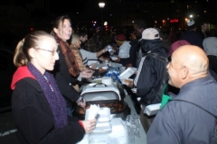 Anne is all smiles as she serves food to the homeless this Monday night.
