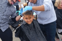 A homeless boy's hair gets cut and he's excited at our San Diego Easter event.