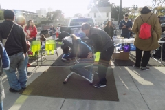 The light shines down on David as he massages a homeless person's back.
