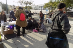 A homeless man writes out a lid at the Lids of Encouragement table.