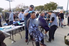 Two San Diego homeless men have their hair cut.