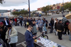 The Lids of Encouragement lid table as the homeless line up for a hot meal on Easter.