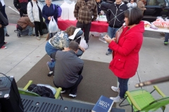 David massages a homeless women as his wife helps.