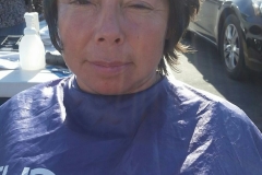 A homeless woman smiles while Tammy cuts her hair.
