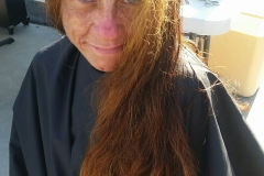 BEFORE: A homeless woman smiles as she gets ready for her hair cut!