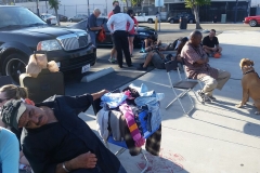 The homeless line up to get their hair cut downtown.