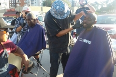 Roberto trims a homeless man's goatee in downtown San Diego.