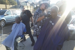 Sprays of light shine down on Mario as he cuts a homeless man's hair.