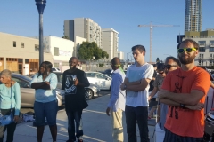 Some Streets of Hope volunteers and a few homeless people circle up to pray.