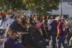 Homeless men getting their hair trimmed downtown.
