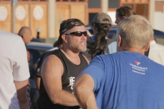 Mark (in blue) listens to a homeless man tell his story.