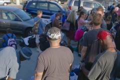 The homeless line up for clothing donations.