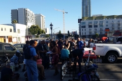 Sherry hold a clipboard and takes down the names of the homeless who want a massage or chiropractic services.