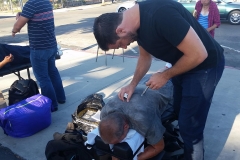 Another photo of Eric helps a homeless man with his chiropractic services.