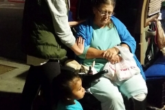 Anne and little Frankie pray for homeless Dorthy in her wheelchair.