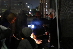 Getting warm by the grill at our Thanksgiving event.