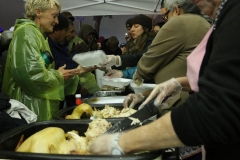 Jenn, Christina and Debra server the homeless a Thanksgiving meal in the rain.