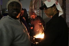 Cooking hot dogs and hamburgers on an open grill downtown to feed the homeless.