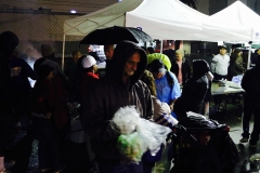 A homeless man puts away his clothing donations after eating a Thanksgiving meal.