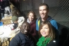Sunshine, Alex, Conrad and Emma standing in the food line ready to feed the homeless.