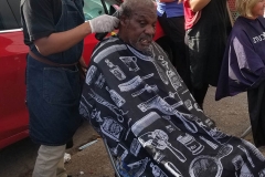 A homeless man get his hair cut by Wylie from Country Club Barber Shop