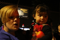 Streets of Hope San Diego volunteer holds a little homeless girl at our Thanksgiving event