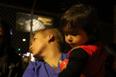Streets of Hope San Diego volunteer holds a little homeless girl at our Thanksgiving event