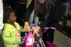 Tammy presents 3 year old homeless girl Christiana a new bike and helmet for Christmas.