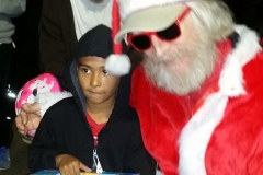 Streets of Hope San Diego Santa gifts a race car to a homeless boy at our Christmas event.