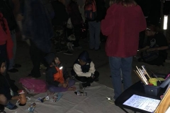 Homeless kids sit on the street in front of the mural being painted at our Christmas event.