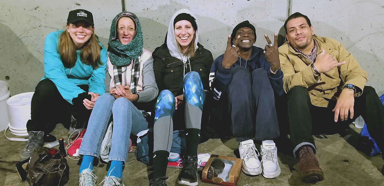 From left to right: Jen, Wendy, Anne, Ben, Zo. Streets of Hope San Diego volunteers provide food, water, and clothing to homeless couple avoiding the rain.