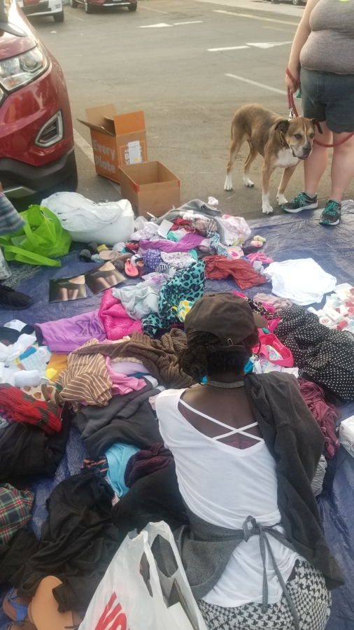 A homeless women sifts through some of the donated clothes remaining.