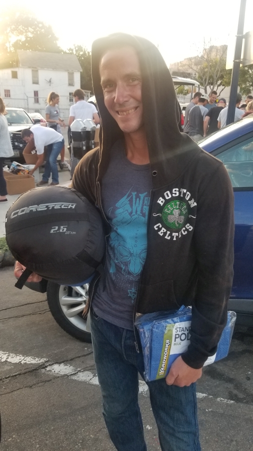 A San Diego homeless man receives a tarp and tent donated by Newport Pacific