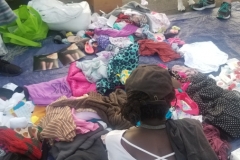 A homeless women sifts through some of the donated clothes remaining.