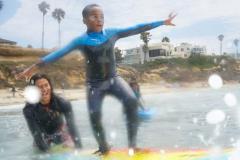 Balancing on the board while learning to surf - Streets of Hope Kids