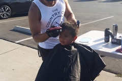 The start of a homeless boy's haircut .